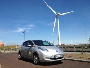 auto elektromobil Nissan Leaf větrná elektrárna větrná turbína v pozadí