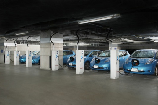 auto elektromobily Nissan Leaf v podzemní garáži u dobíjecích stanic