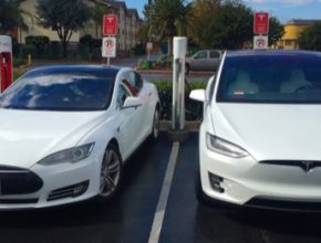 auto elektromobily Tesla Model S a Tesla Model X vedle sebe při nabíjení u nabíjecí stanice Tesla Supercharger ve městě Gilroy