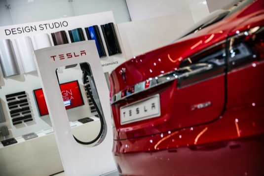 auto elektromobil Tesla Model S zadek u nabíjecí stanice Tesla Supercharger