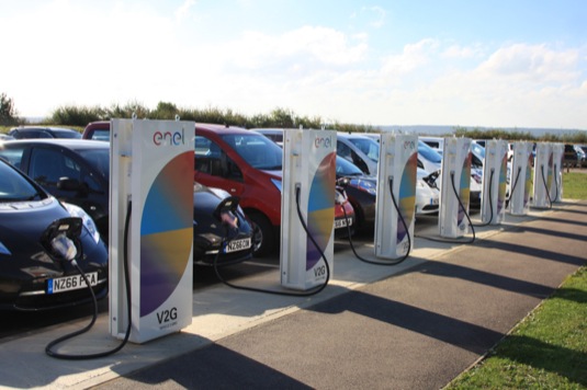 auto elektromobily Nissan Leaf u nabíjecích stanic V2G - vehicle to grid, které pomáhají napájet středisko pro výzkum a vývoj Nissanu v Británii