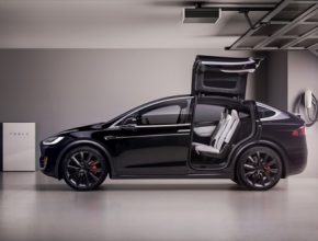 auto elektromobil Tesla Model X v garáži, vlevo domácí baterie Tesla Powerwall
