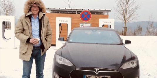 auto elektromobil Tesla Model S u nabíjecí stanice Supercharger a Karl-Thomas Neumann