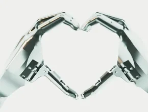 Ruce robota Tesla Optimus svírající tvar srdce. foto: Tesla